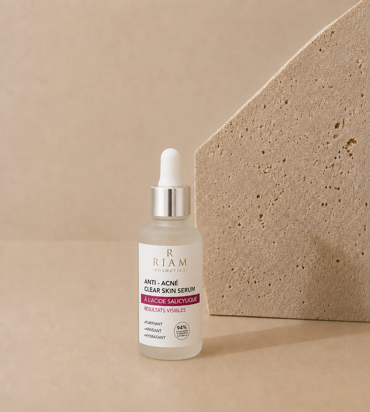 Flacon Clear Skin Serum Riam Cosmetics à l'acide salicylique sur fond beige.